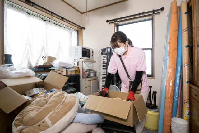ゴミ屋敷を片付けてる女性の業者
