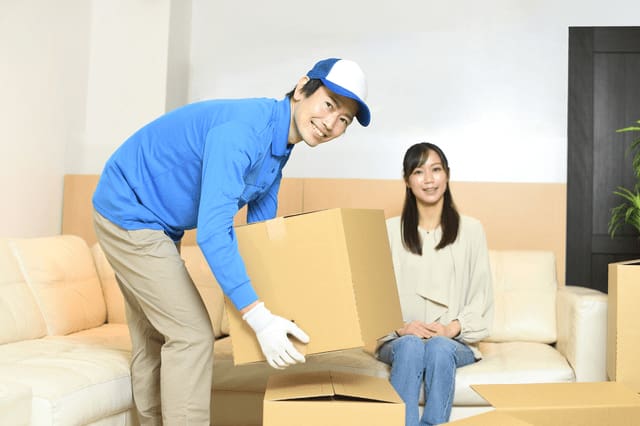 ソファーに座っている女性と作業スタッフ