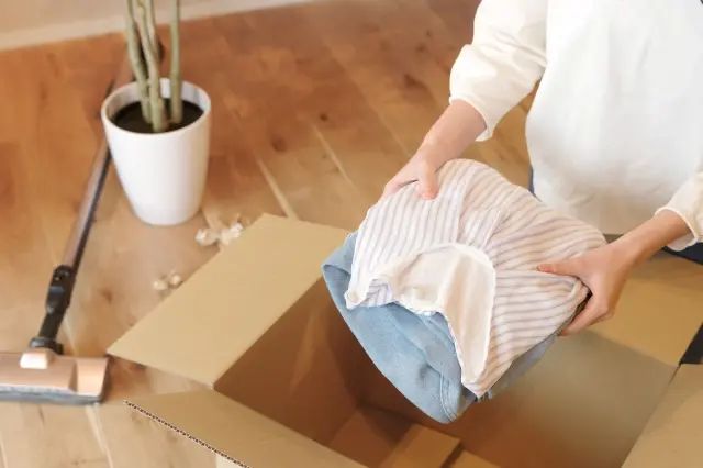 段ボールに荷物をまとめる女性