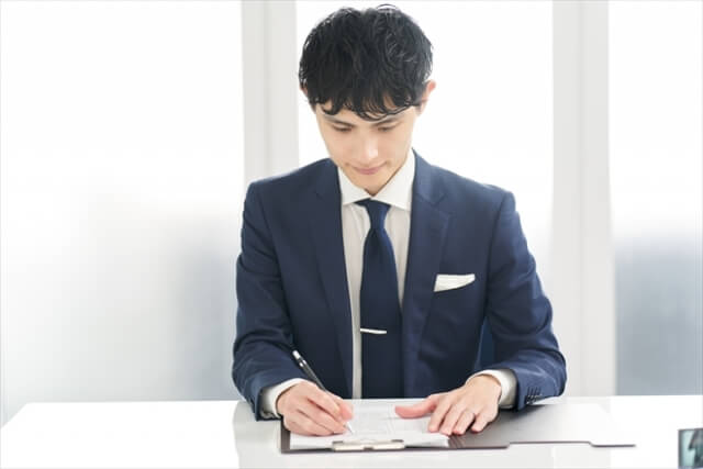 用紙に記入するビジネスマン