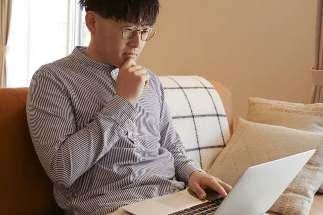 リビングでパソコンを使っている若い男性