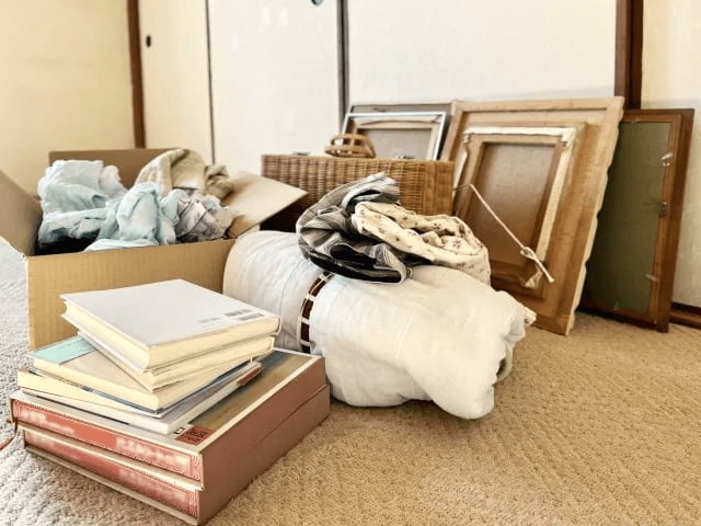 段ボール箱に入れた衣類と本といくつかの額縁