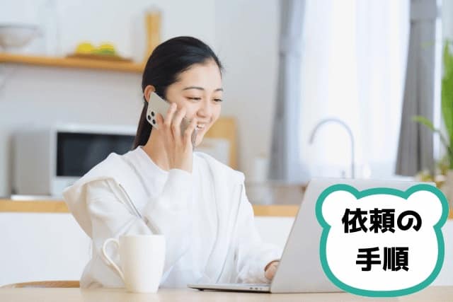 パソコンの前で電話をしてる女性