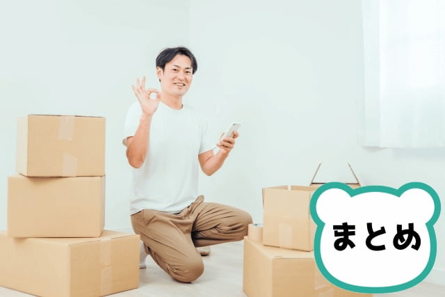 ダンボールとスマホを使う男性