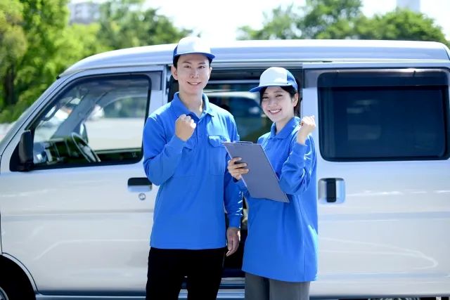 車の前にいる作業員の男女