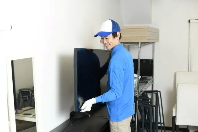 テレビを運ぶ作業員