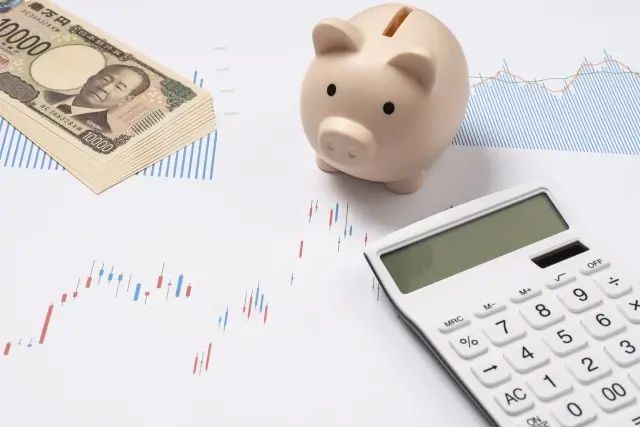 新紙幣と株価チャートと貯金箱と電卓