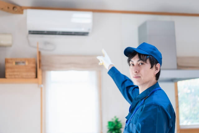 エアコンを指さしている男性