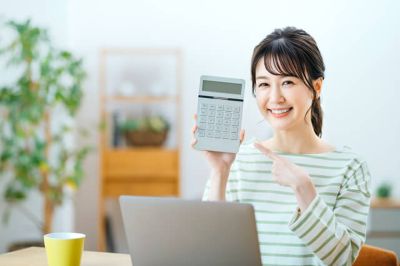 電卓を指さししてる笑顔の女性