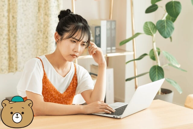 パソコンの前で悩む女性