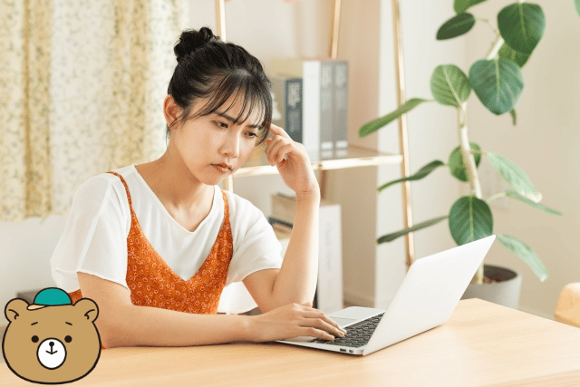 パソコンの前で悩む女性
