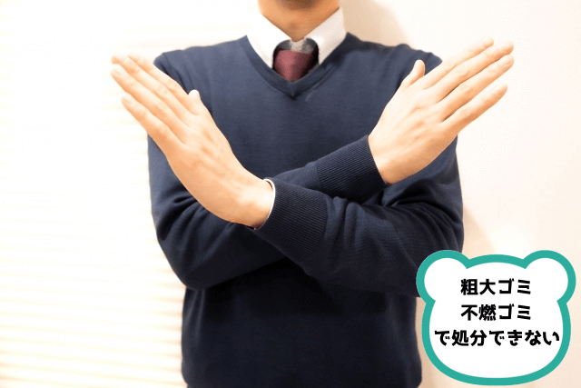手でバツをつくる男性
