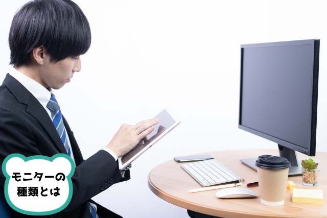 デスク前でタブレットを操作する若い日本人サラリーマン