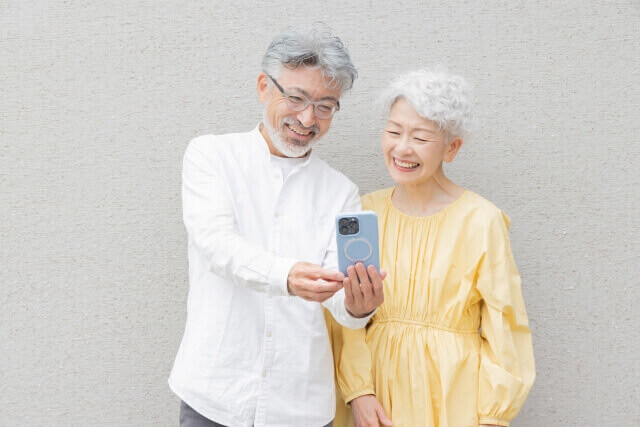 スマートフォンを使う笑顔のシニアカップル