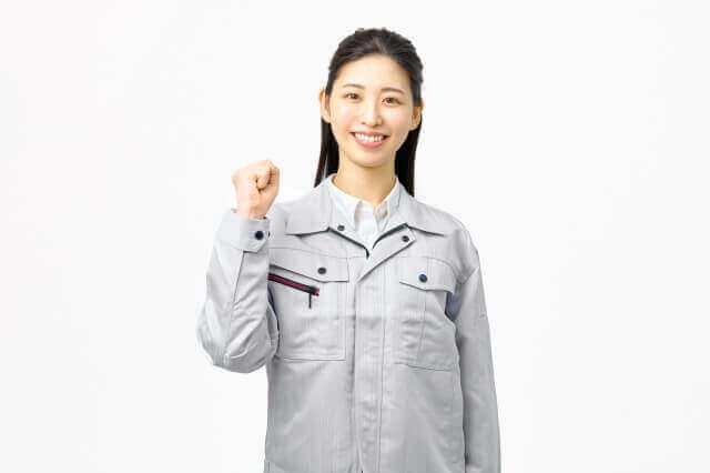 作業服を着てガッツポーズする女性