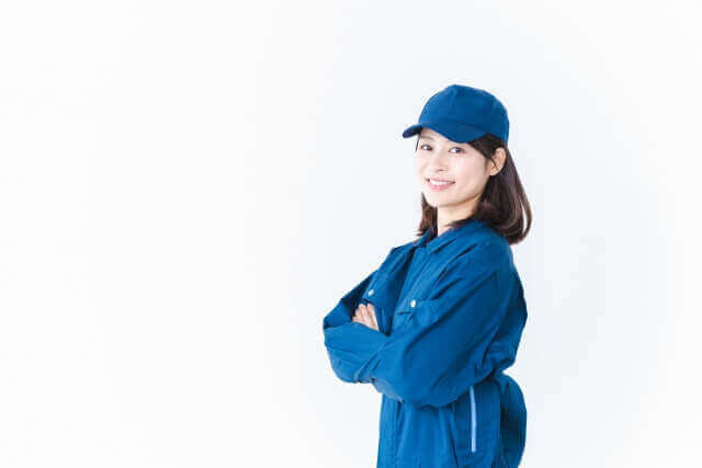 作業服を来て笑顔で仕事をする若い女性